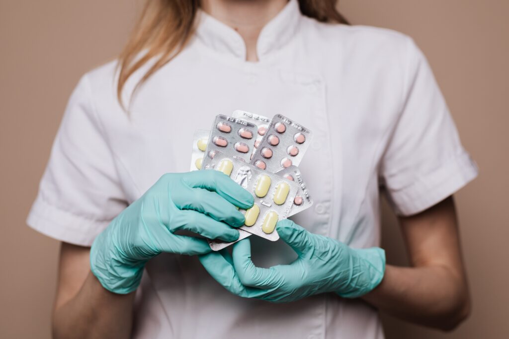 Pharmacist holding a handful of medications.